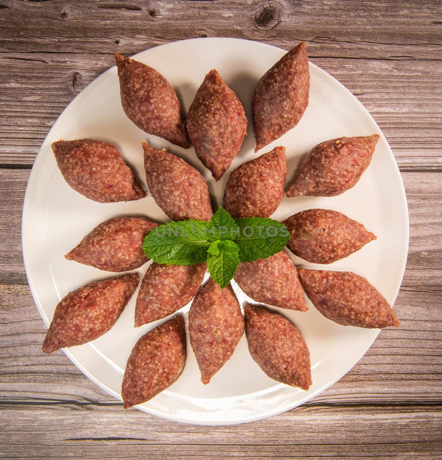 Traditional kebbe and pita bread on big round plate in lebanese restaurant. High quality photo
