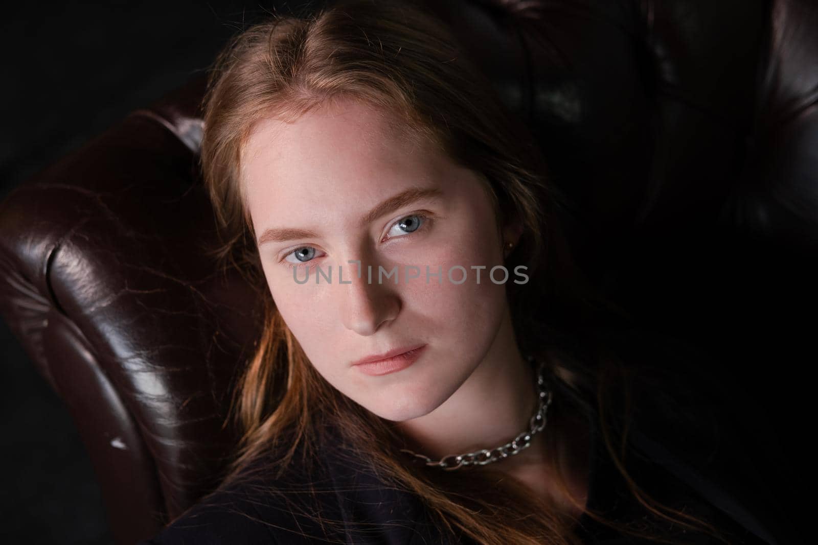 portrait of confident serious brunette woman in black clothes on dark background. femininity.