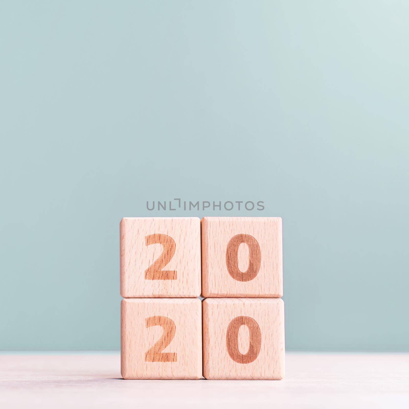 Abstract 2020, 2019 New year target plan design concept - wood blocks cubes on wooden table and pastel green background, close up, blank copy space.