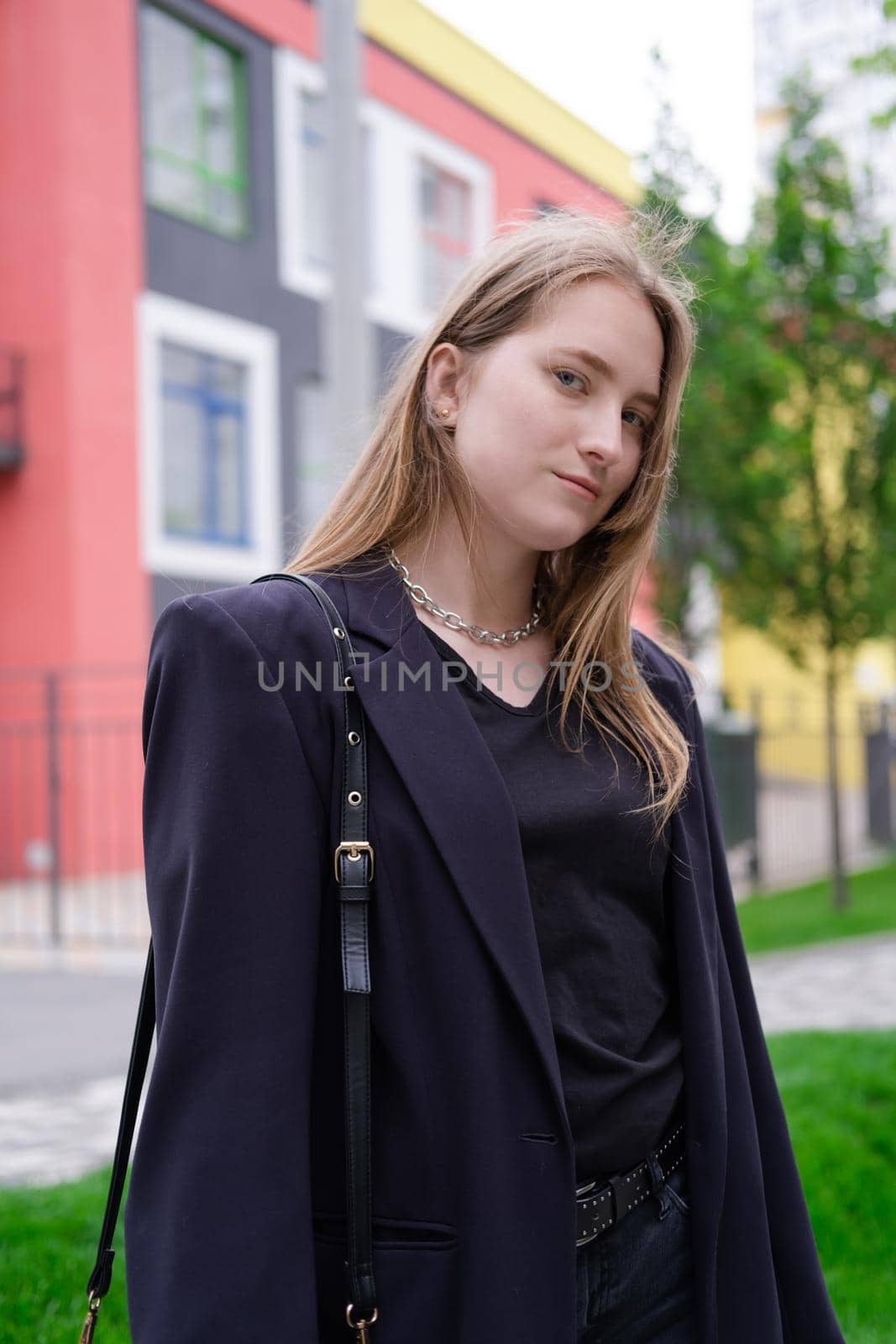 pretty brunette woman on background of bright modern buildings. feminine. millennial people. lady on walk.