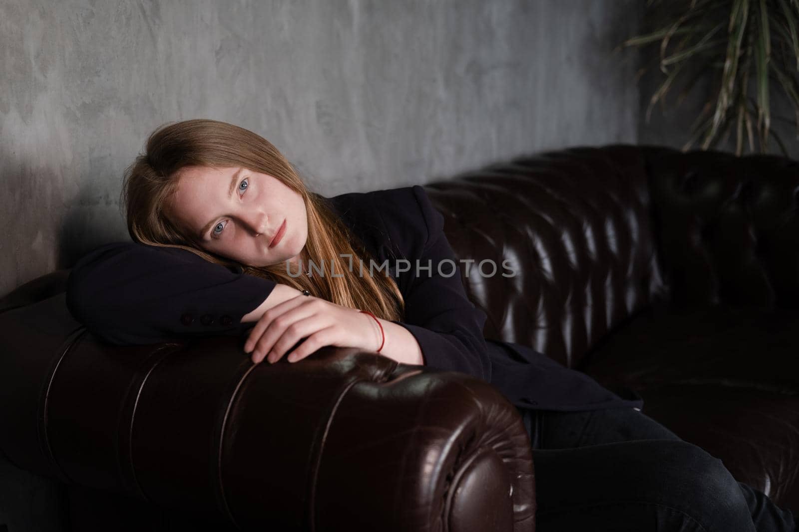 portrait of confident serious brunette woman in black clothes on dark background. femininity.