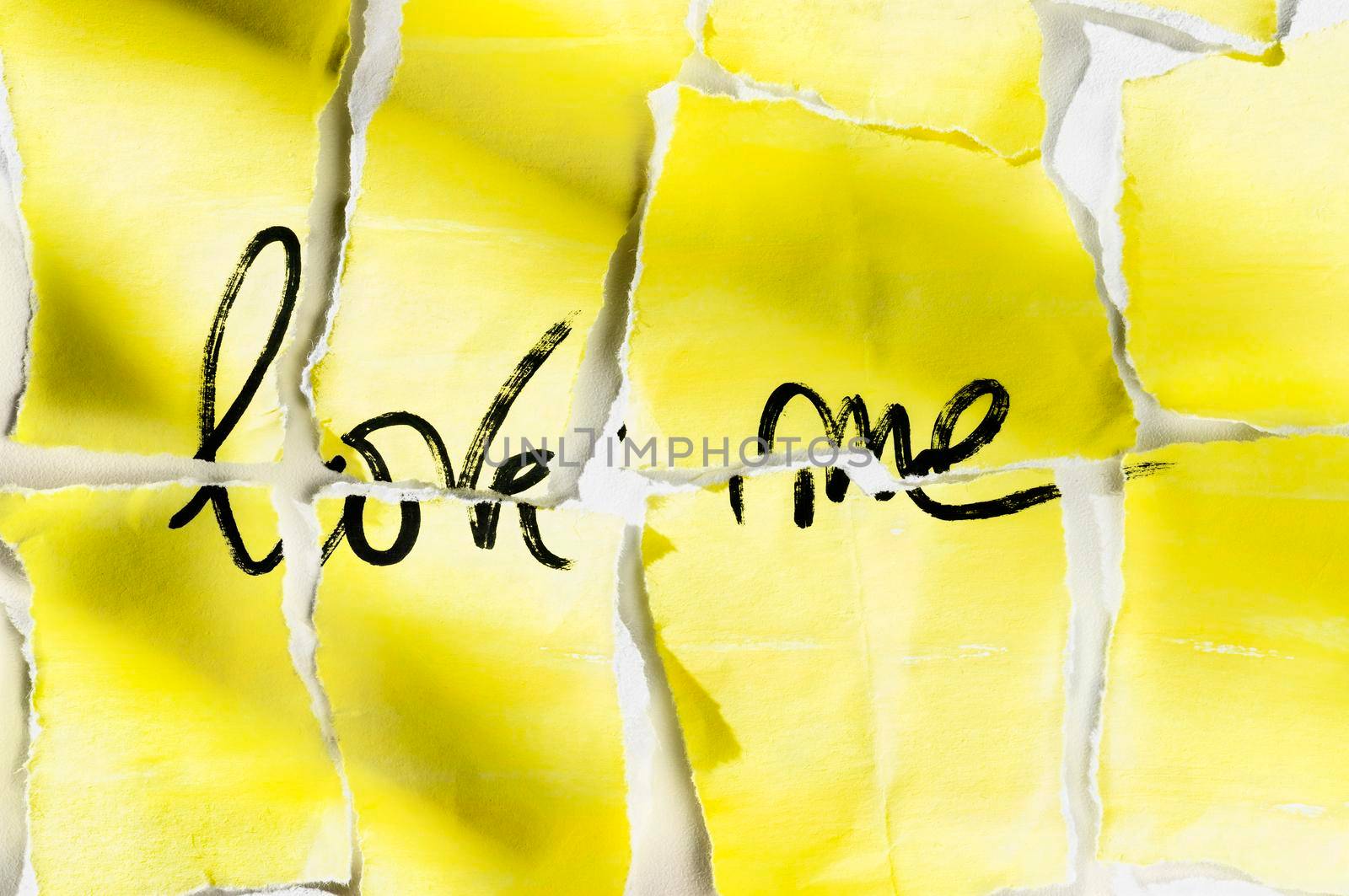 Yellow ripped paper with words LOVE ME on white background ,handwritten words with black pen