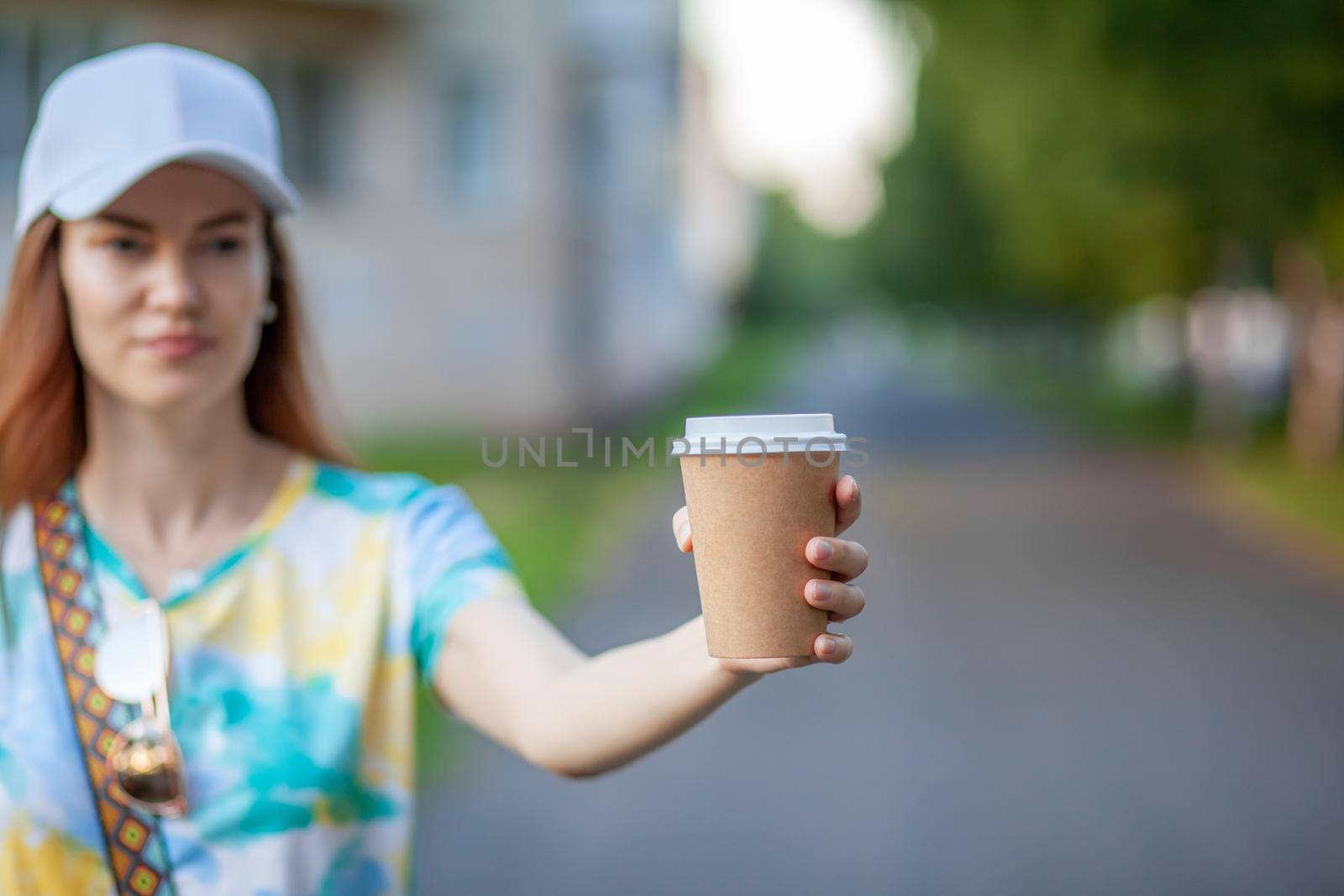 White paper cup with coffee in woman hand. Time for drink coffee in city. Coffee to go. Enjoy moment, take a break. Disposable paper cup closeup. Delicious hot beverage. Blank space for text, mockup