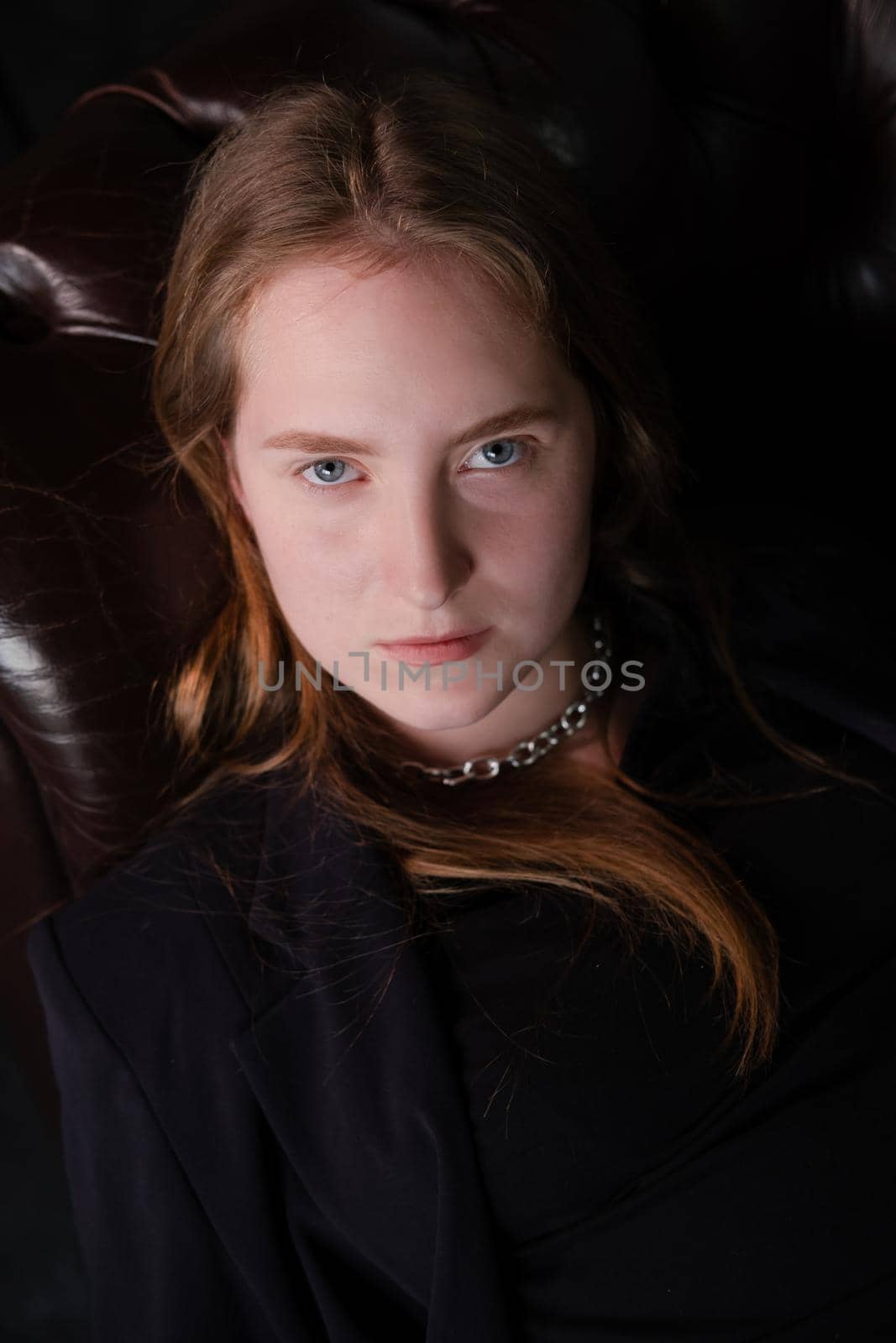 portrait of confident serious brunette woman in black clothes on dark background. femininity by oliavesna