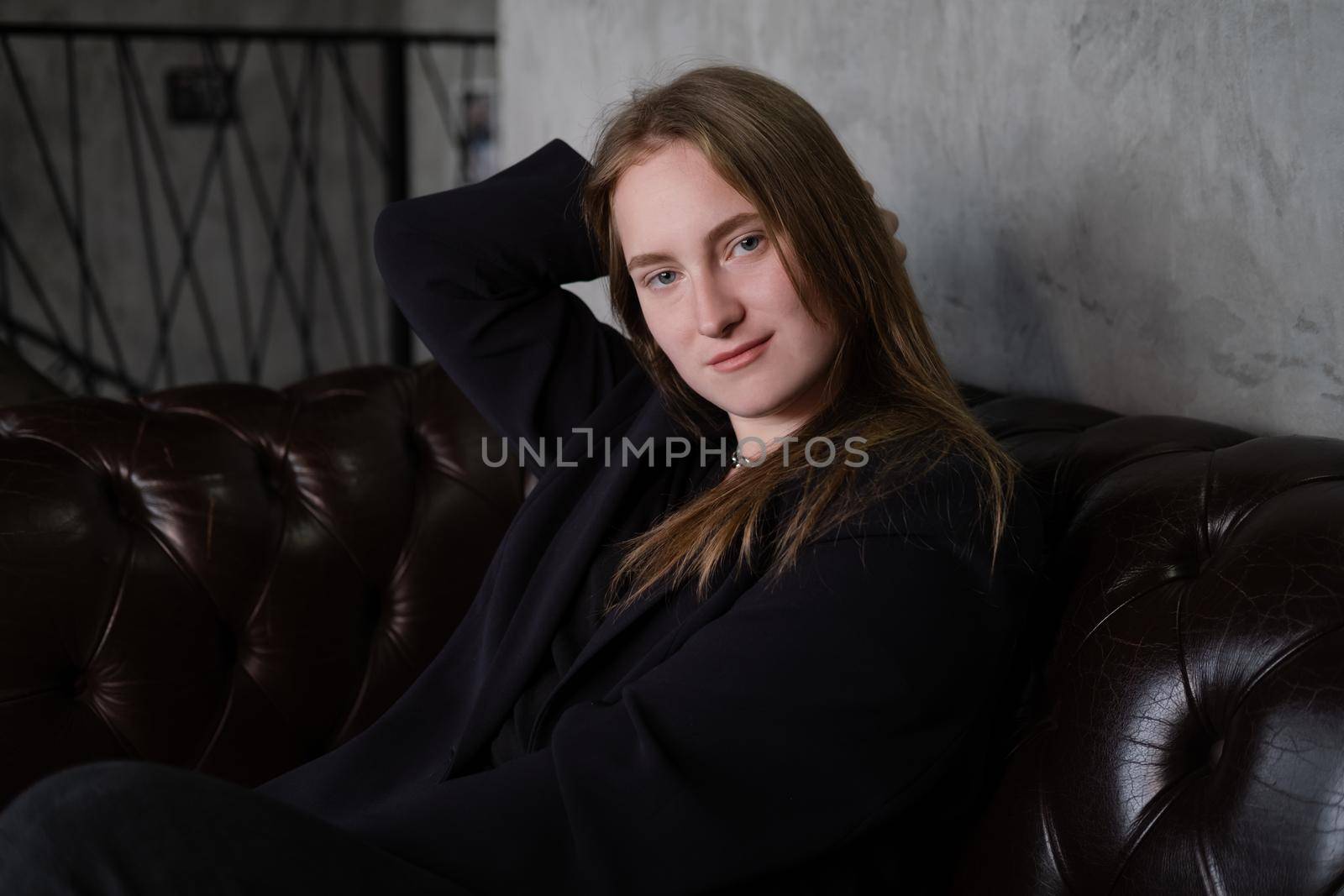 portrait of confident serious brunette woman in black clothes on dark background. femininity.
