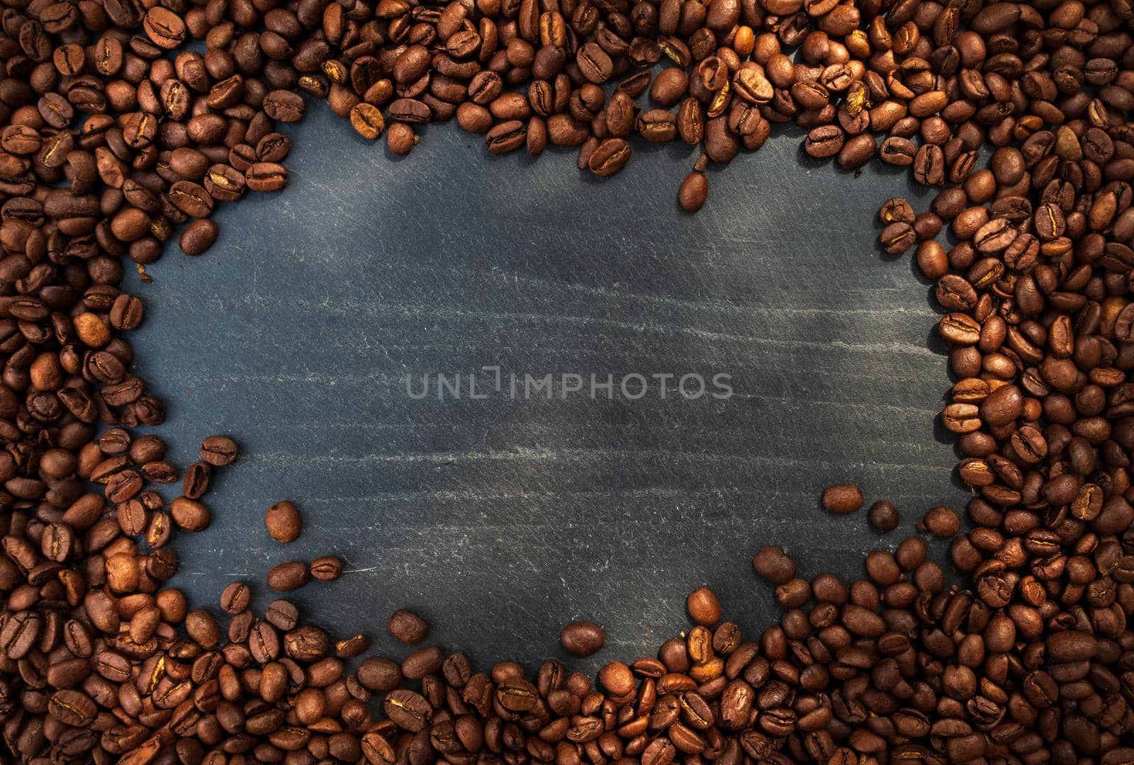 Coffee beans over slate. Top view. Free space for text