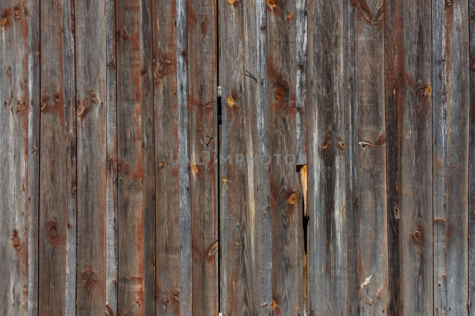 artistic texture of an old wooden planks fence in black and brown tones - close-up rustic background
