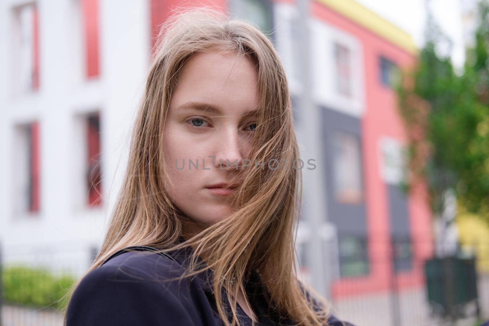 pretty brunette woman on background of bright modern buildings. feminine. millennial people. lady on walk.