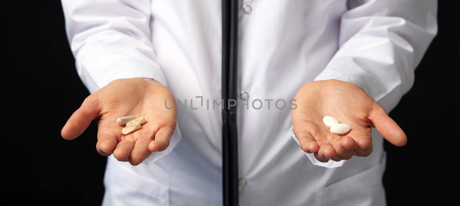 Cropped view of female Doctor holding in hands Pills to choose. Difficult Choice between drugs. Placebo drugs concept. Healthcare concept. by Mariakray