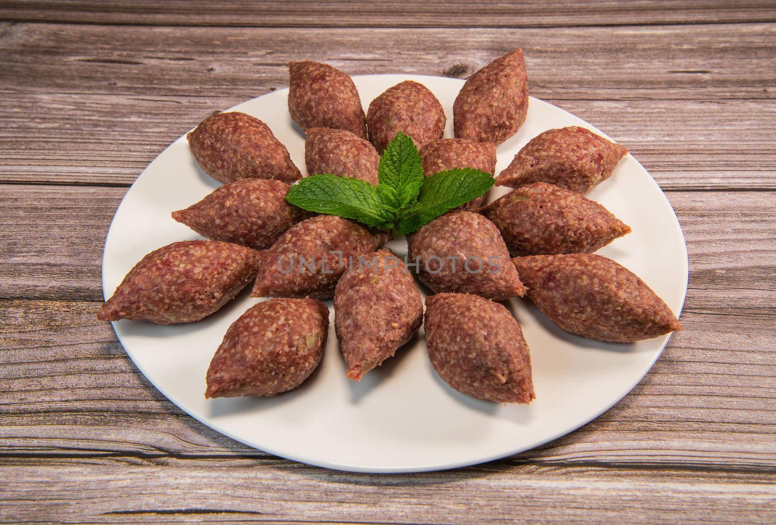 Traditional kebbe and pita bread on big round plate in lebanese restaurant. High quality photo