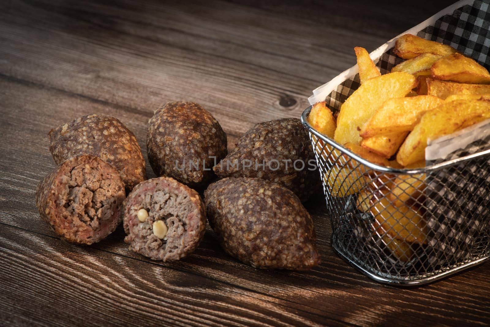 Traditional kebbe and pita bread on big round plate in lebanese restaurant. High quality photo