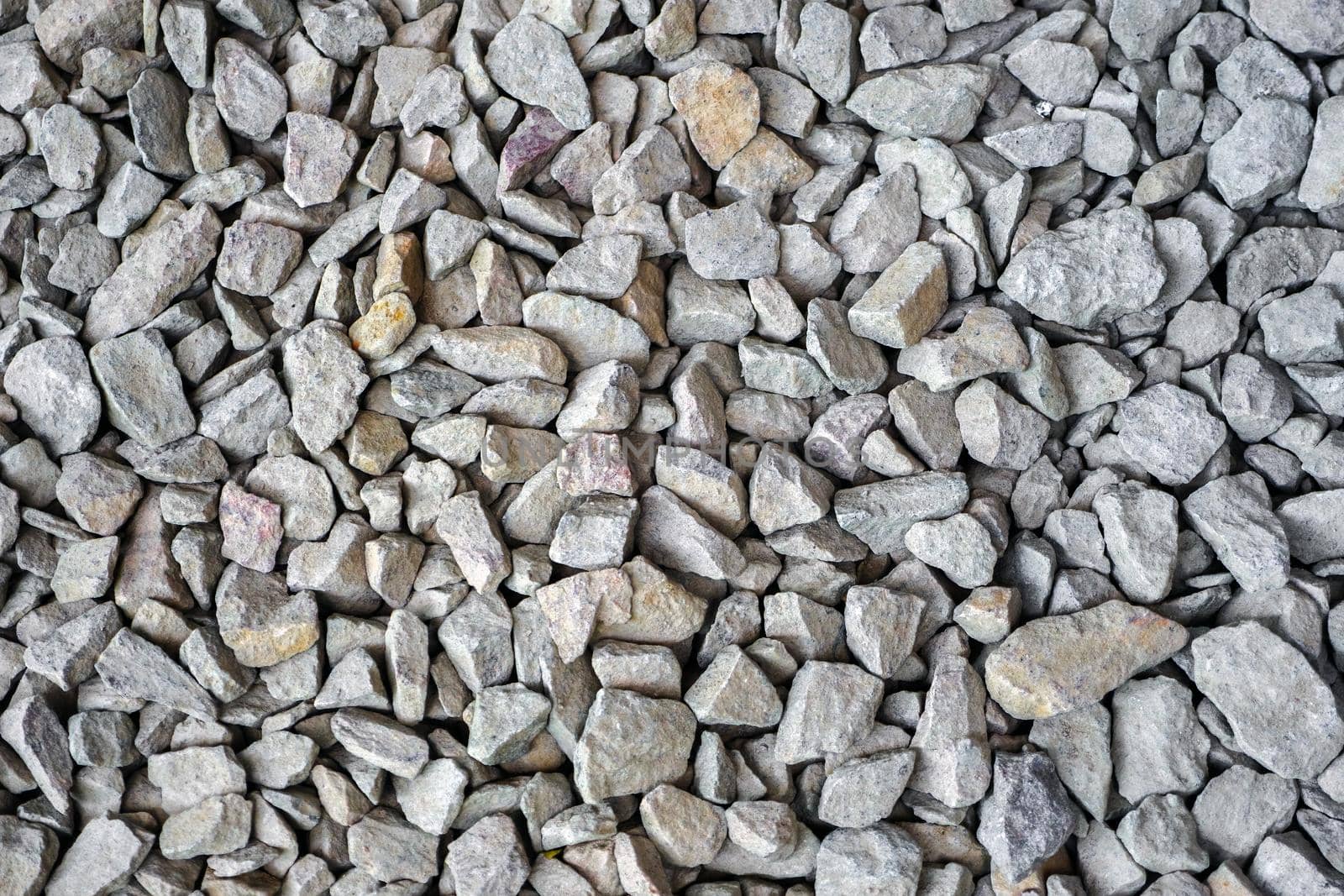 Crushed rock close up. Small rocks ground. Small stone construction material. Crushed stones building. Garden gravel background stone landscaping. Closeup Gravel road. Building material gravel texture by synel