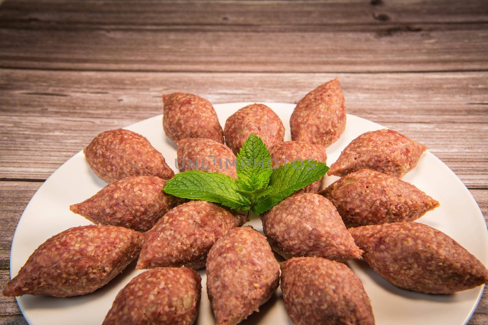 Traditional kebbe and pita bread on big round plate in lebanese restaurant. High quality photo