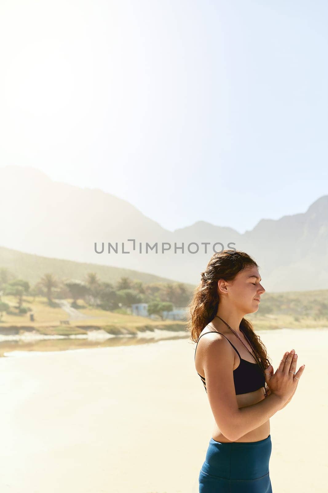 Yoga has a profound influence on your mind. a beautiful young woman practising yoga on the beach. by YuriArcurs