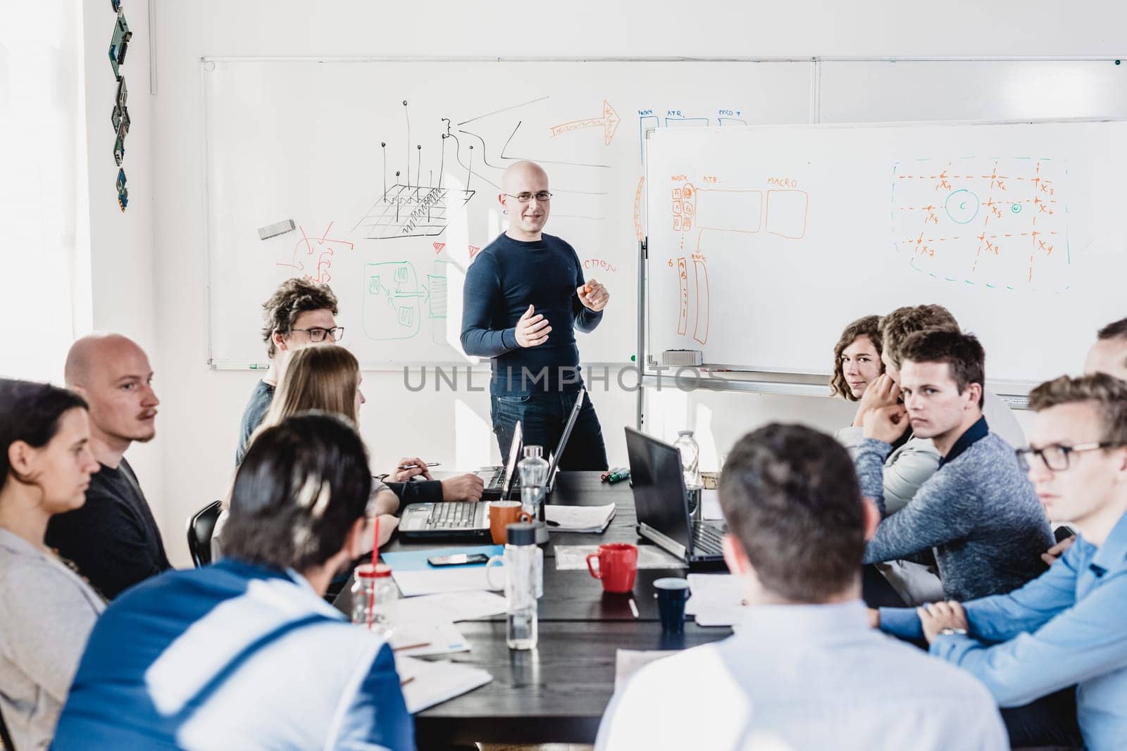 Relaxed informal IT business startup company meeting. Team leader discussing and brainstorming new approaches and ideas with colleagues. Startup business and entrepreneurship concept.