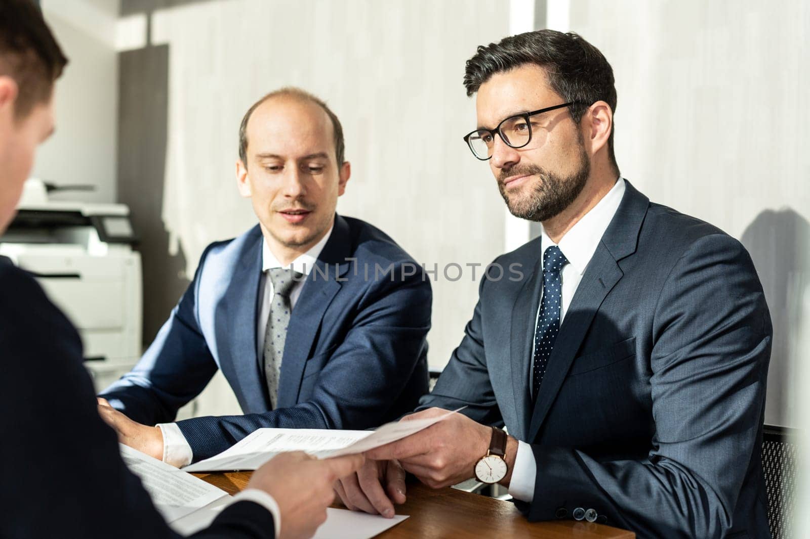 Group of confident successful business people reviewing and signing a contract to seal the deal at business meeting in modern corporate office. by kasto