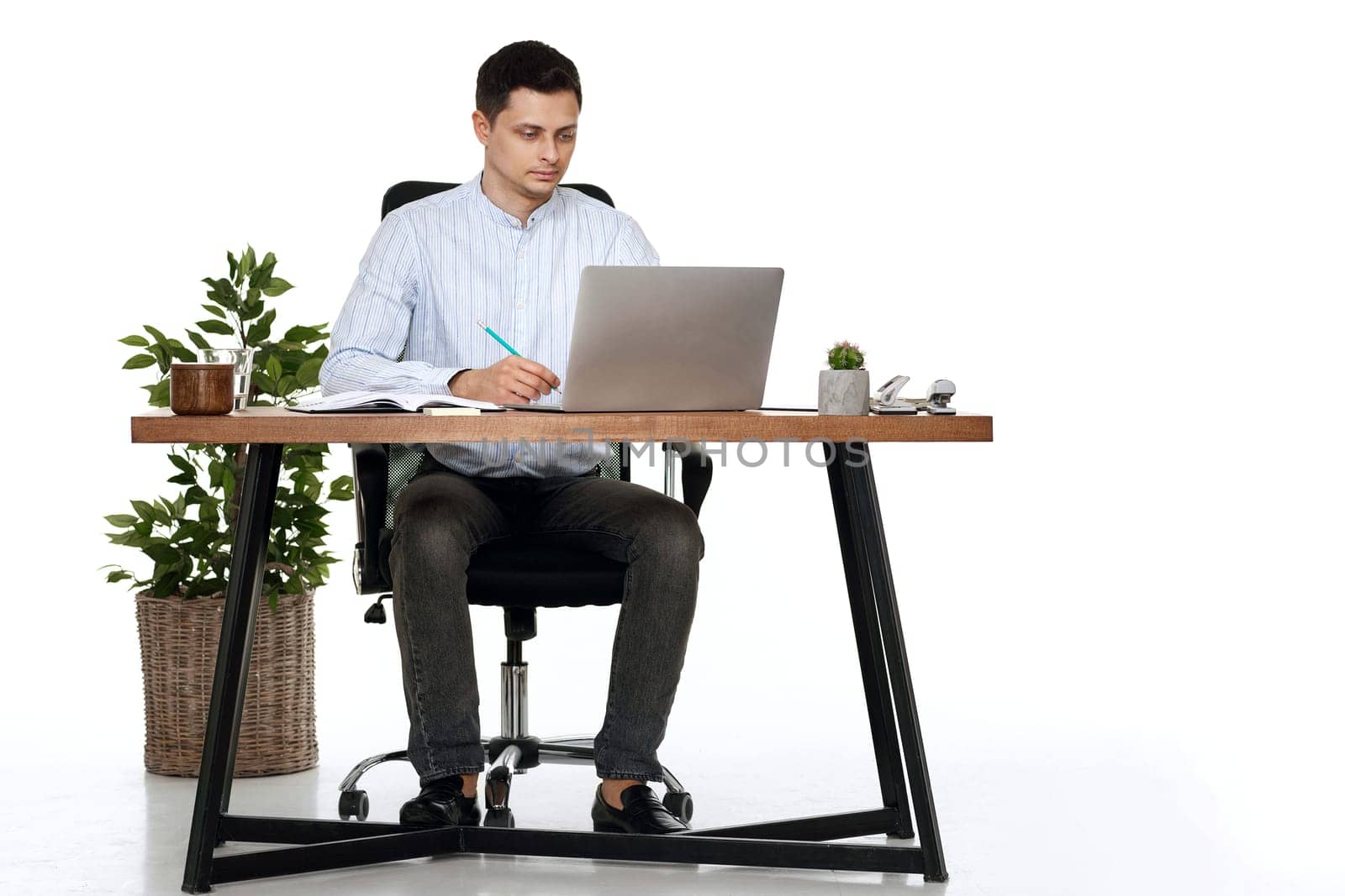 young businessman using laptop computer for online work at table on white background
