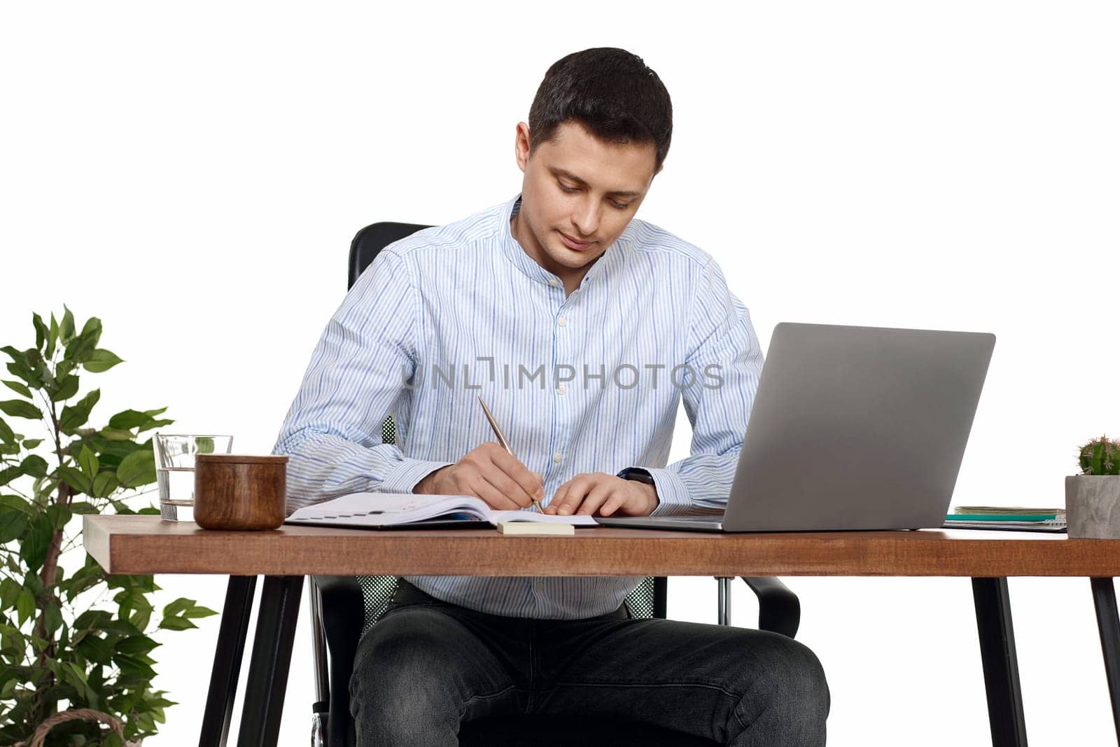 businessman in blue shirt taking notes, using laptop computer on white background