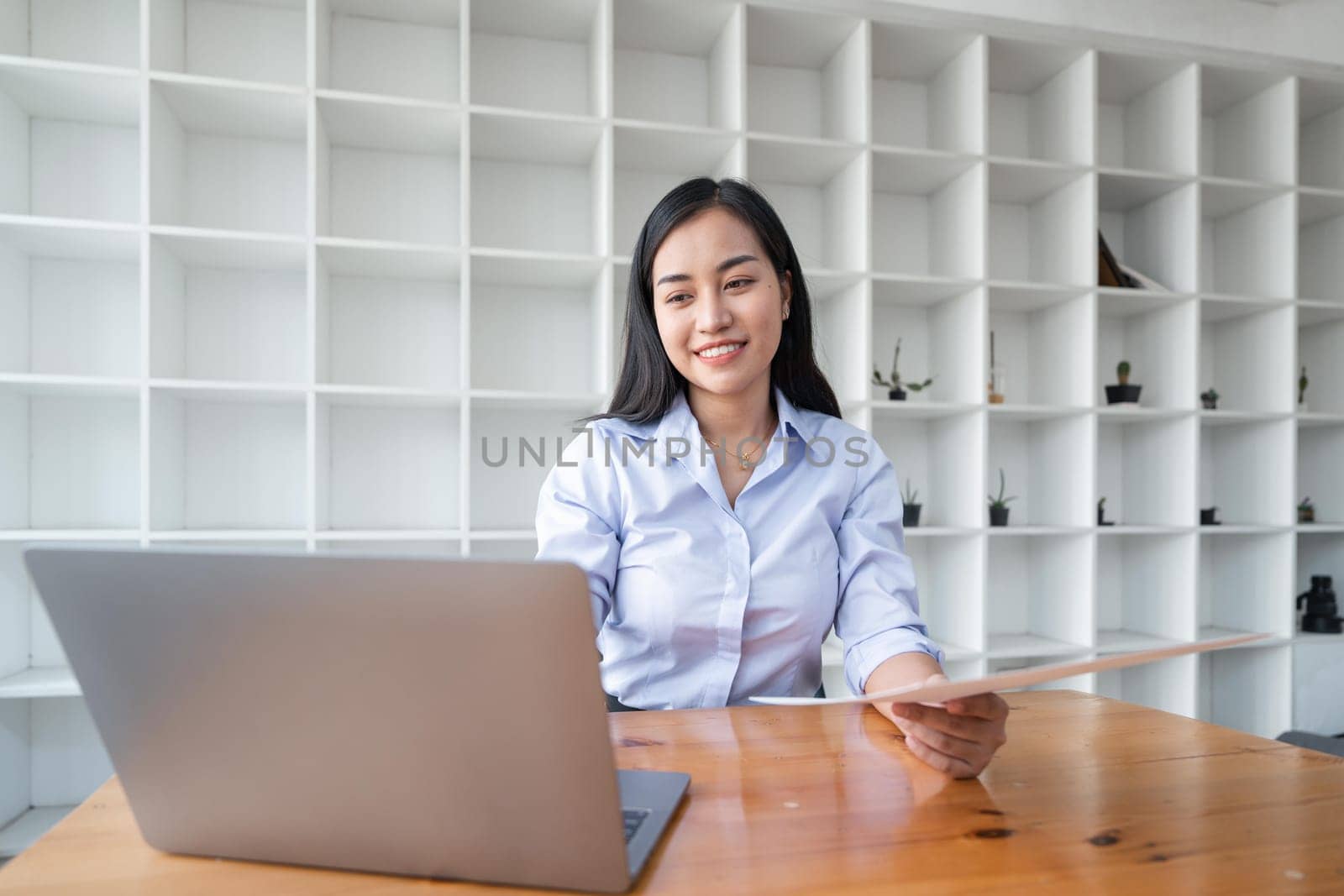 Asian businesswoman working for financial graphs showing results about their investments, planning successful business growth process by laptop computer.