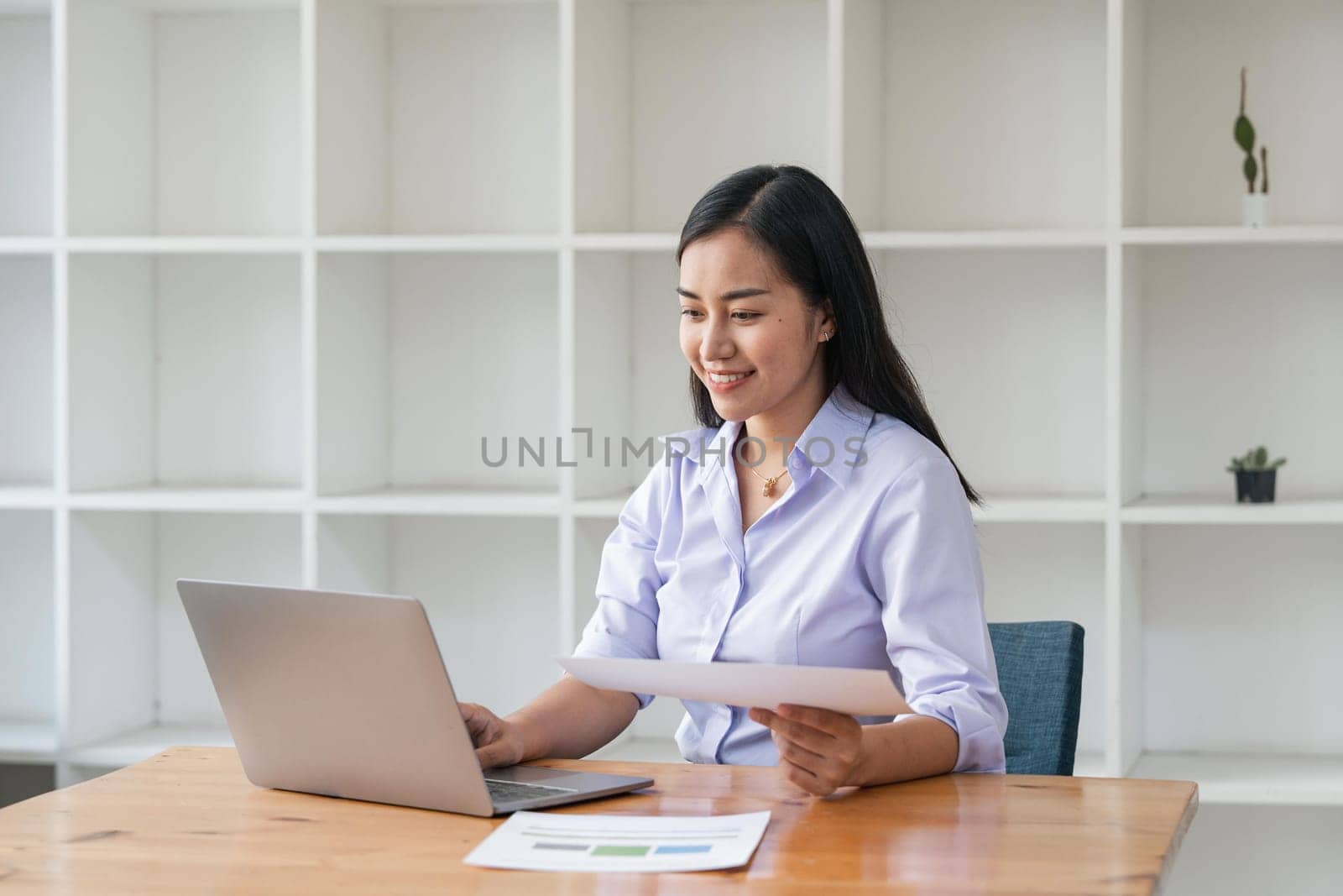 Asian businesswoman working for financial graphs showing results about their investments, planning successful business growth process by laptop computer.