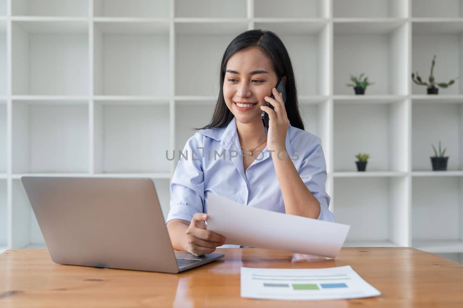 Asian businesswoman working for financial graphs showing results about their investments, planning successful business growth process by laptop computer.