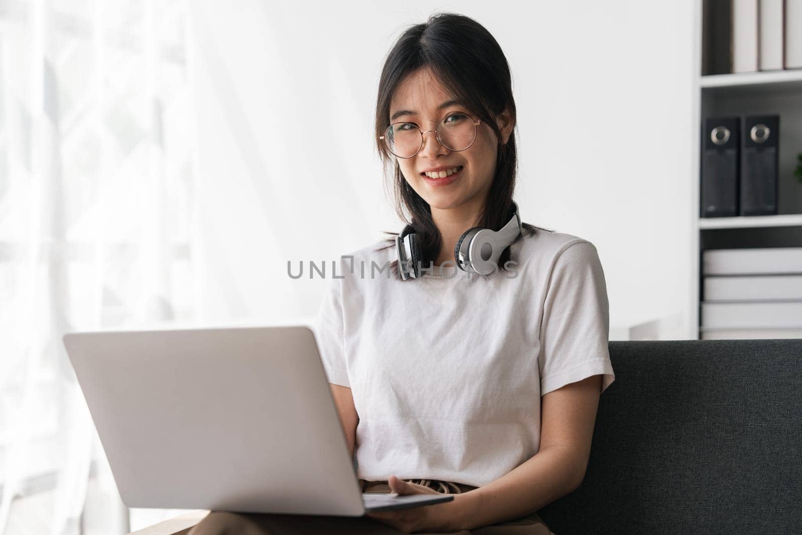 Beautiful young asian student girl using a laptop computer learning online at home. Online learning education..