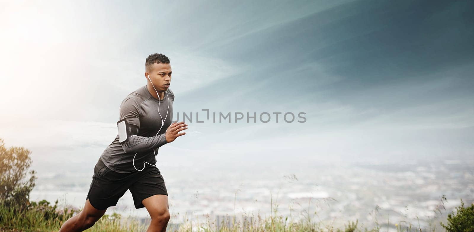 Man, running and space for fitness with cityscape for exercise, wellness or music with mockup for health. African male runner listening to audio for focus, workout and nature outdoor with mock up sky.