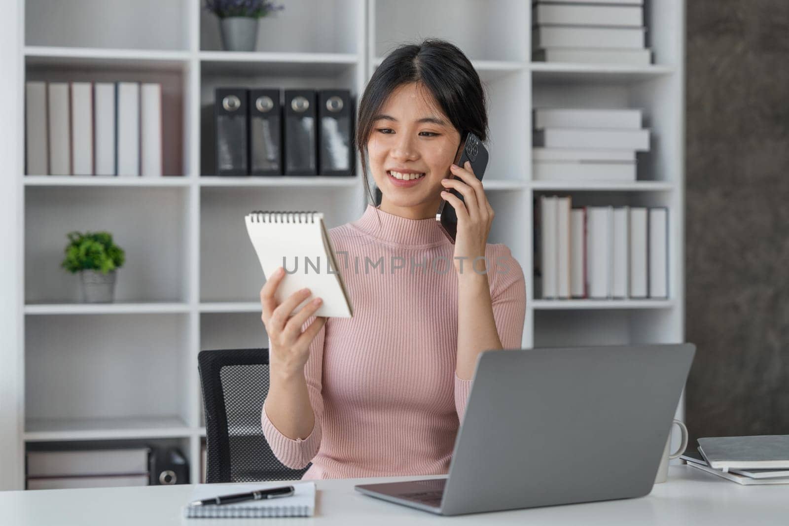 Young woman student busy study make notes in notebook and using laptop concentrated online training course technology education..