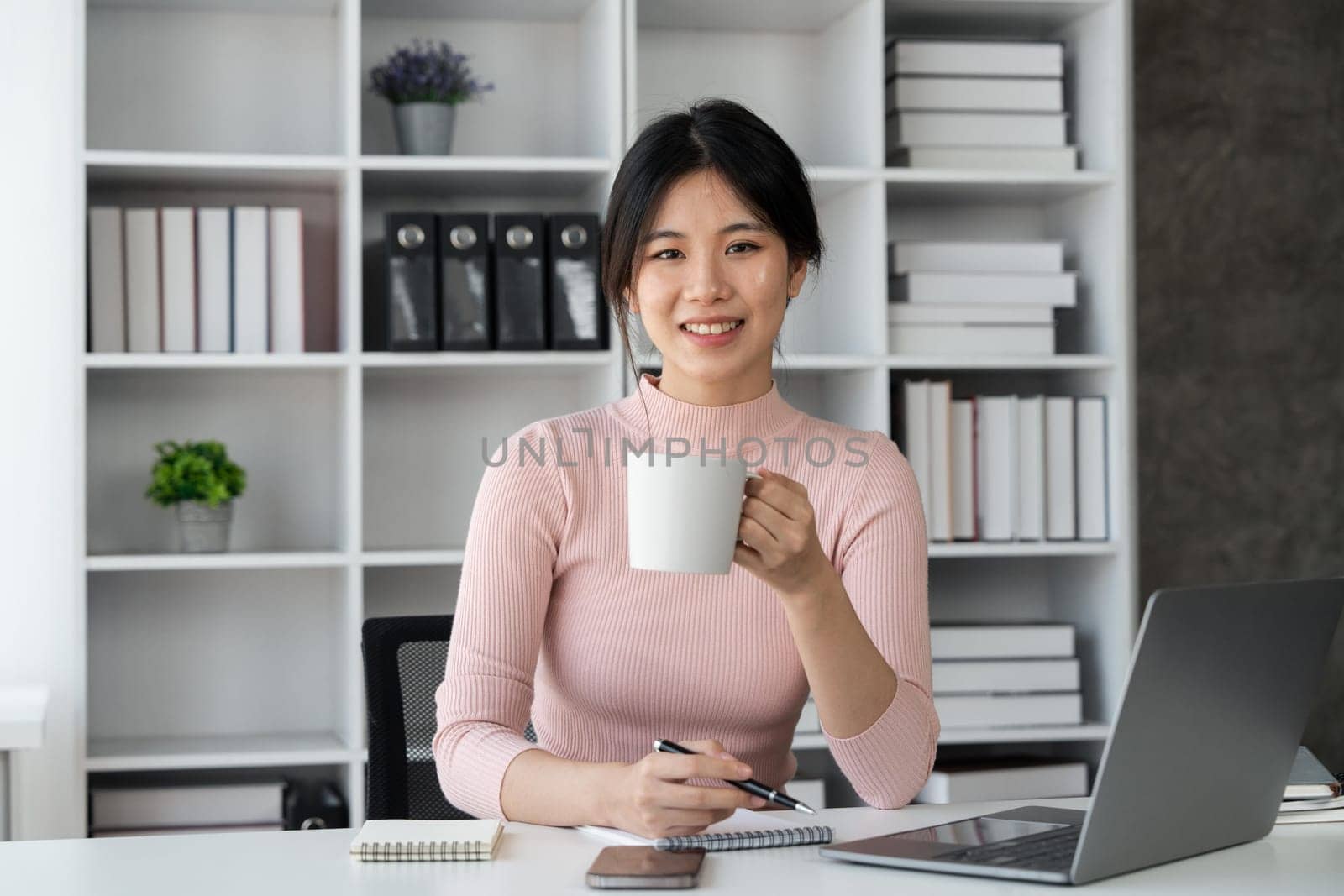 Young woman student busy study make notes in notebook and using laptop concentrated online training course technology education..