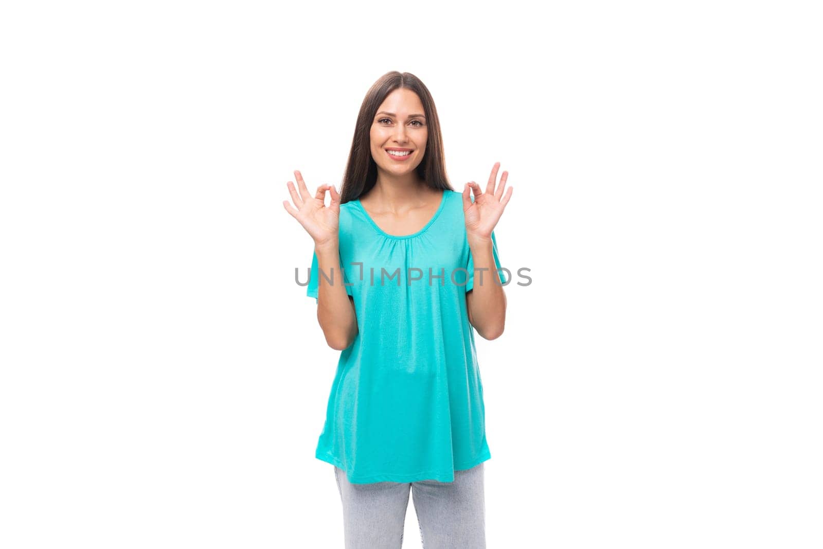young caucasian female model with black straight hair is wearing a blue t-shirt on a studio white background with copy space.