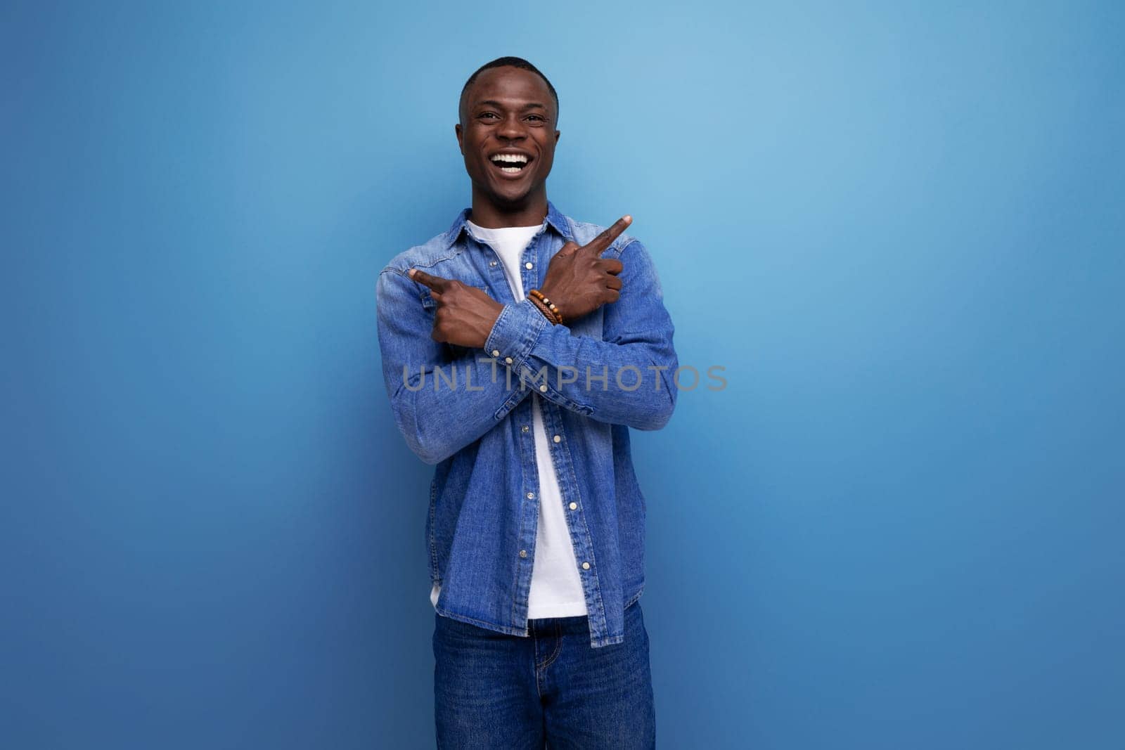 handsome confident young attractive african man dressed casually in denim on background with copy space by TRMK