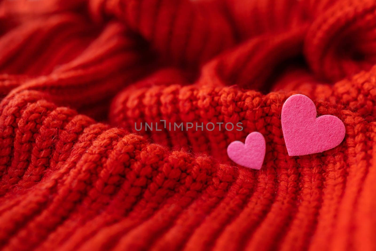 Decorative pink heart on a red knitted background, top view. Place for an inscription, horizontal photo