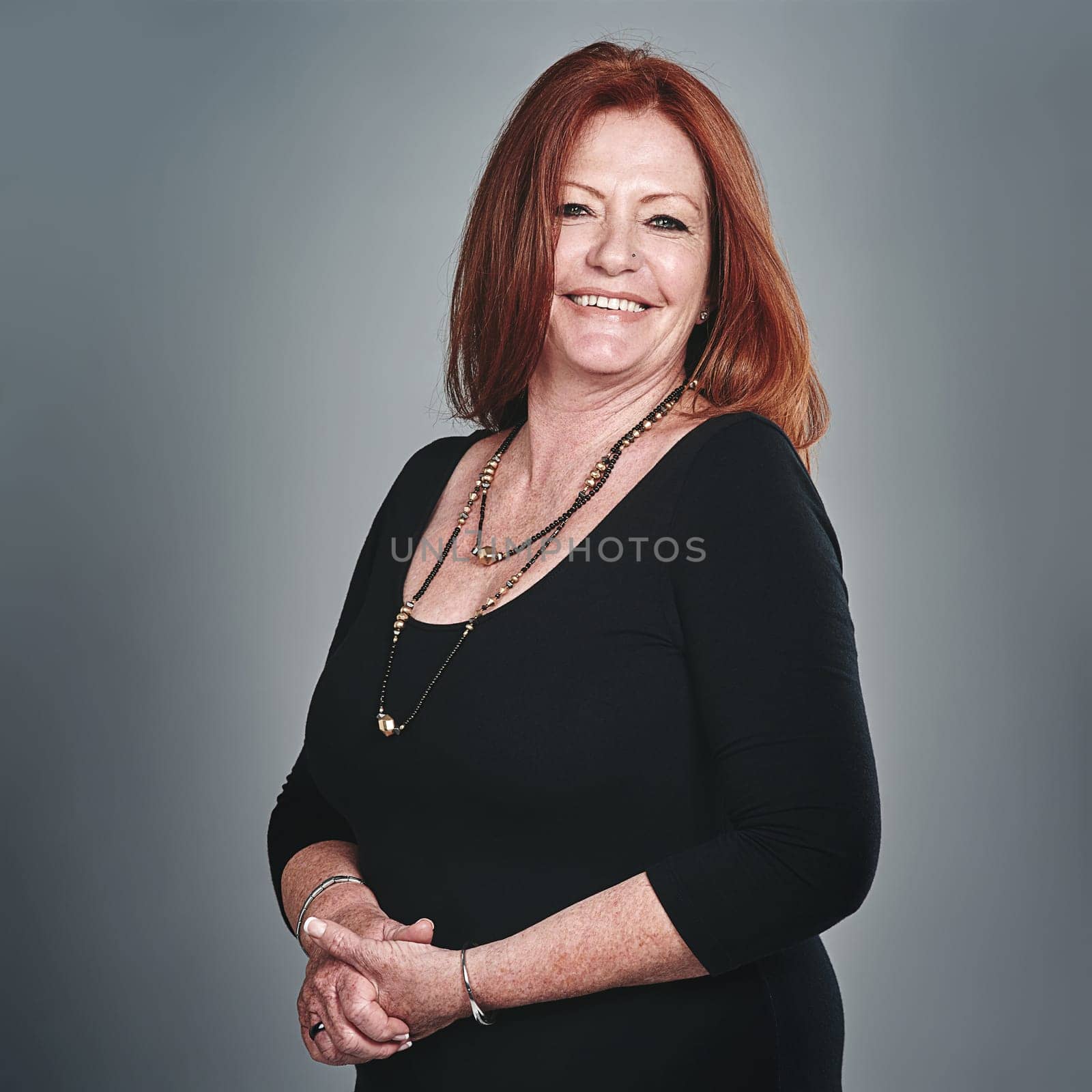 Passionate about personal and professional improvement. Studio portrait of a happy mature businesswoman posing against a grey background. by YuriArcurs