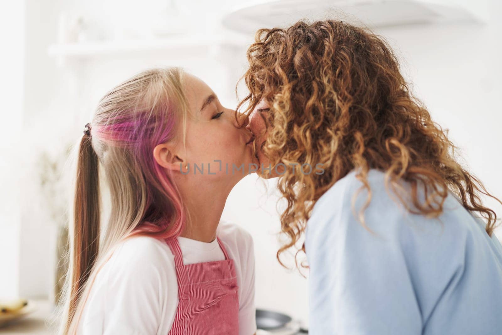 Teen blonde girl kissing her mother , close up by Fabrikasimf