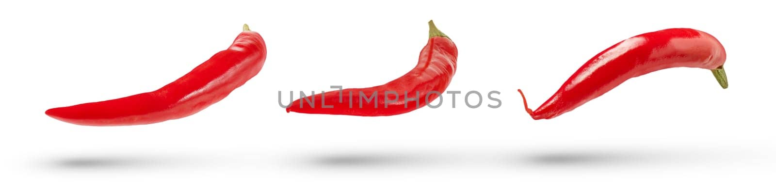 Pods of red hot peppers of various sizes and shapes fall on a white isolated background, casting a shadow. Fresh red pepper for insert in design or project, isolated on white, close up