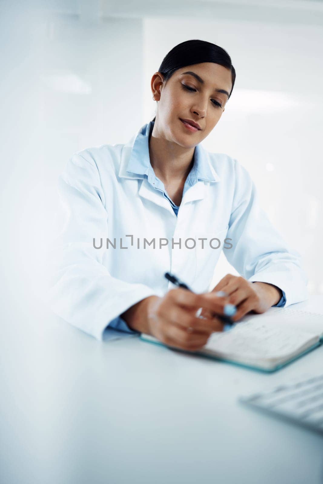 Woman, scientist and writing in book for research in science discovery, breakthrough or information at lab. Female person or medical expert with notebook for scientific data or results in laboratory by YuriArcurs