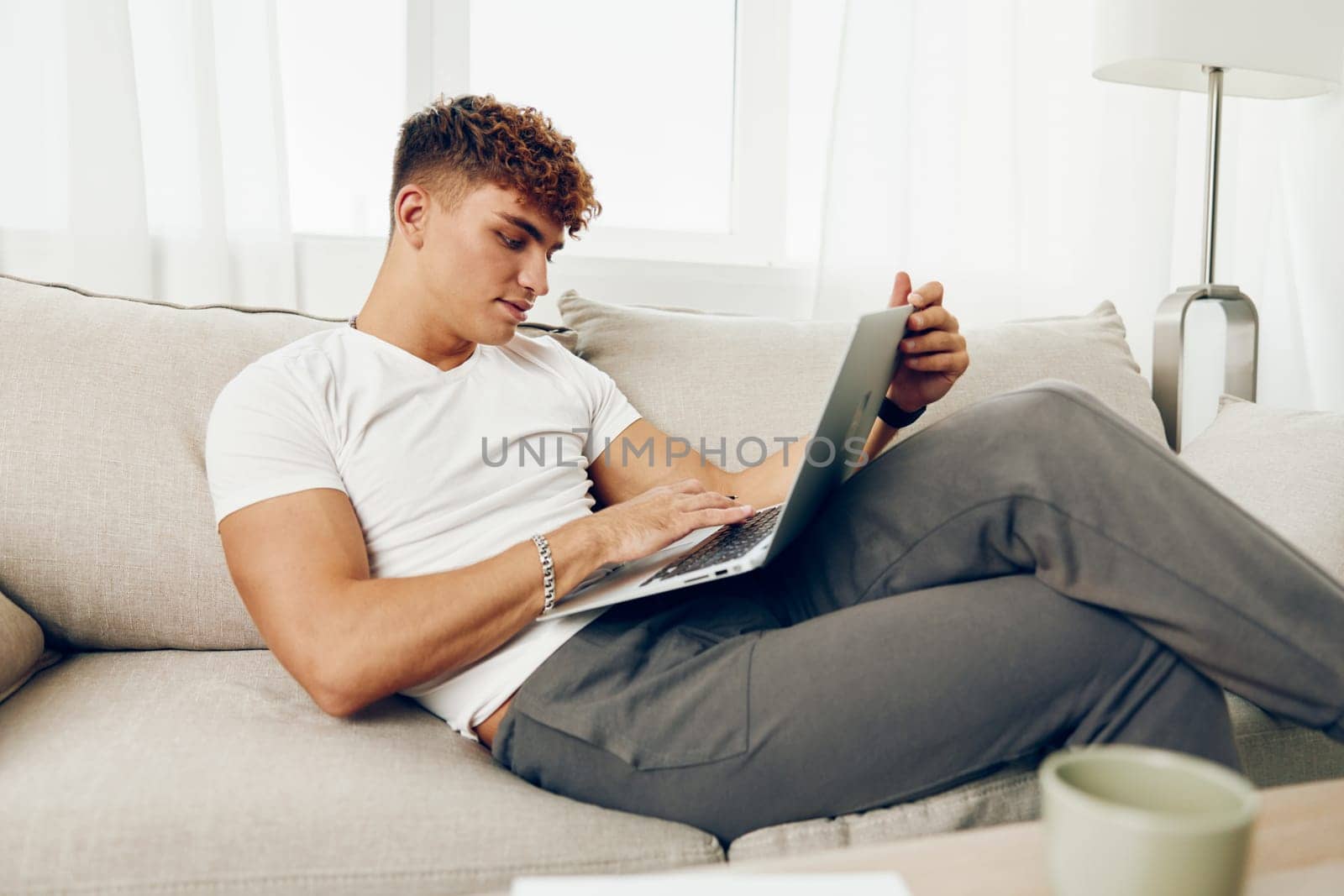 man interior notebook modern business cup blissful lifestyle cyberspace online indoor communication phone typing computer laptop browsing caucasian sitting