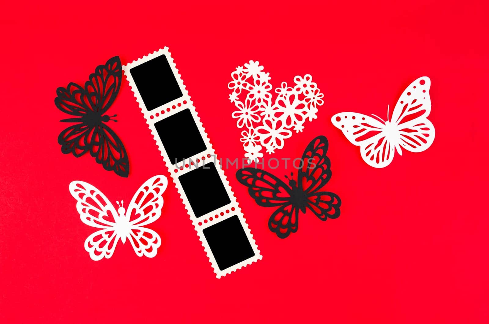Cinema strip photo paper frames with butterfly paper on red background. Save clipping path.