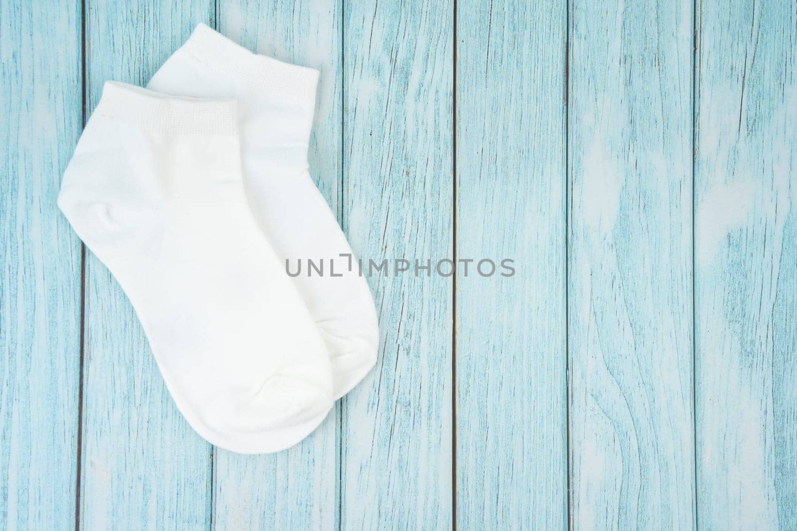 White cotton socks for design on blue wooden background.