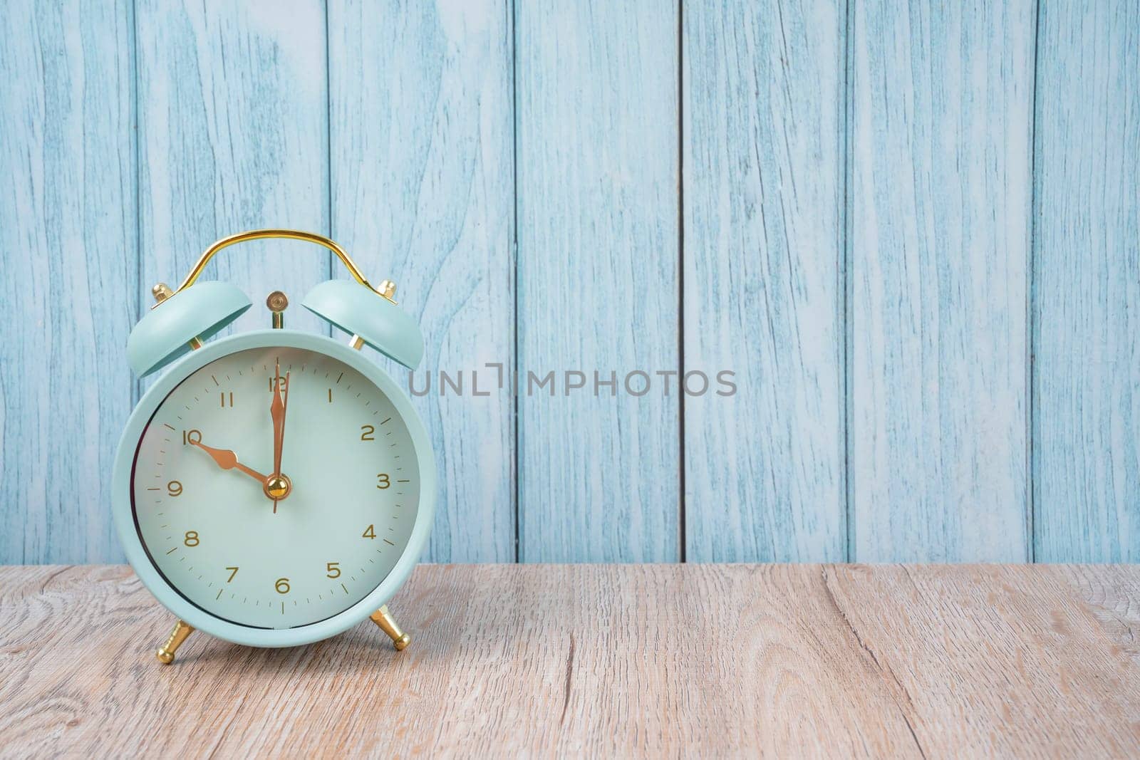 The vintage retro alarm clock ten time 10 o'clock on table wood with dark background. by Gamjai
