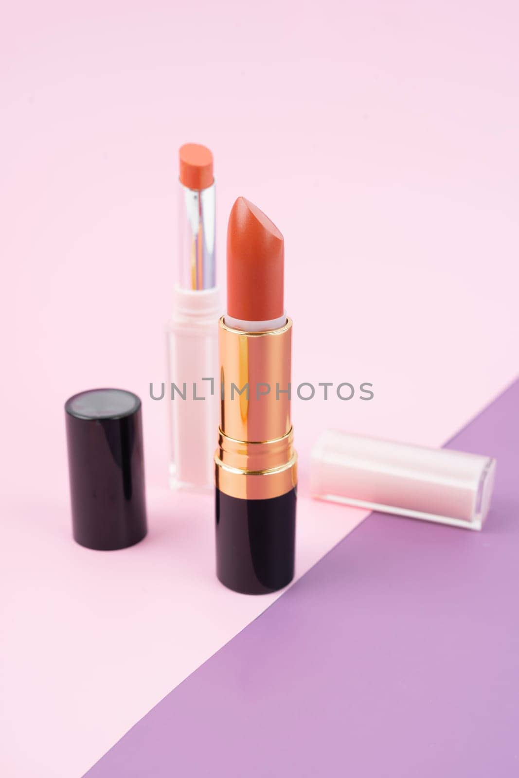 The Orange color lipsticks on beautiful background. by Gamjai