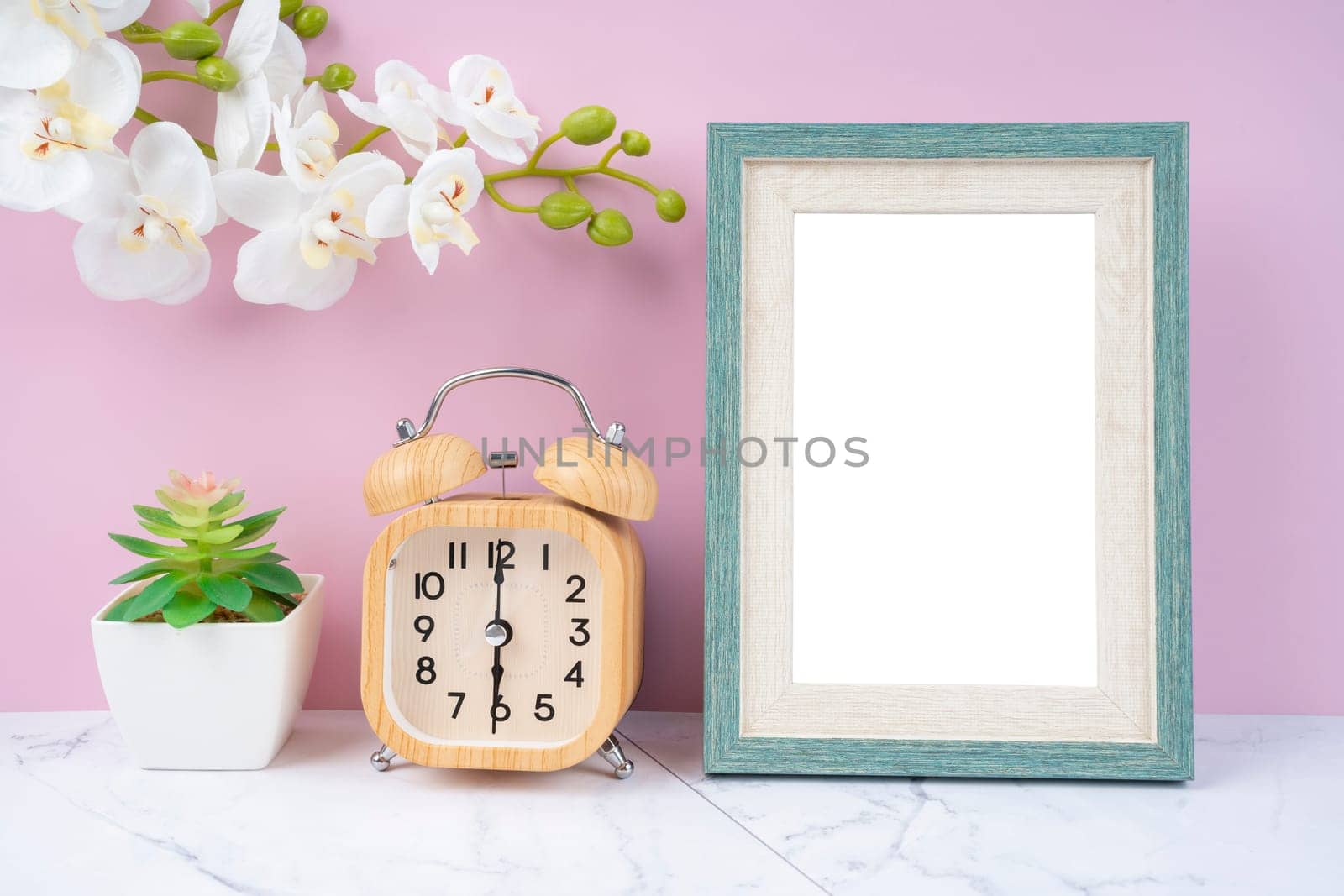 Blank picture frame and alarm clock on black floor with copy space and clipping path for the inside.