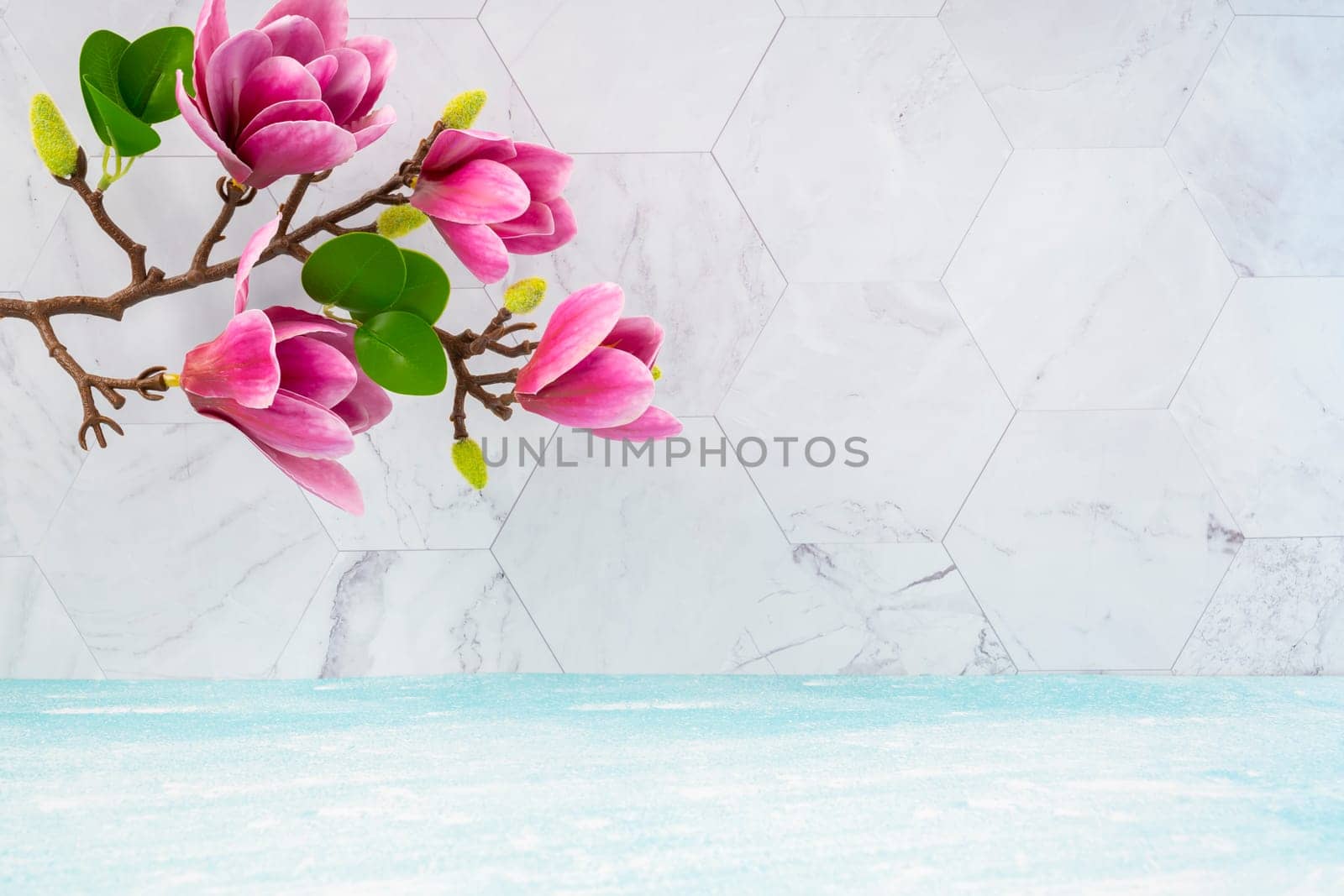 The Beautiful pink magnolia flowers on blue wooden floor and marble background with copy space for your design. by Gamjai