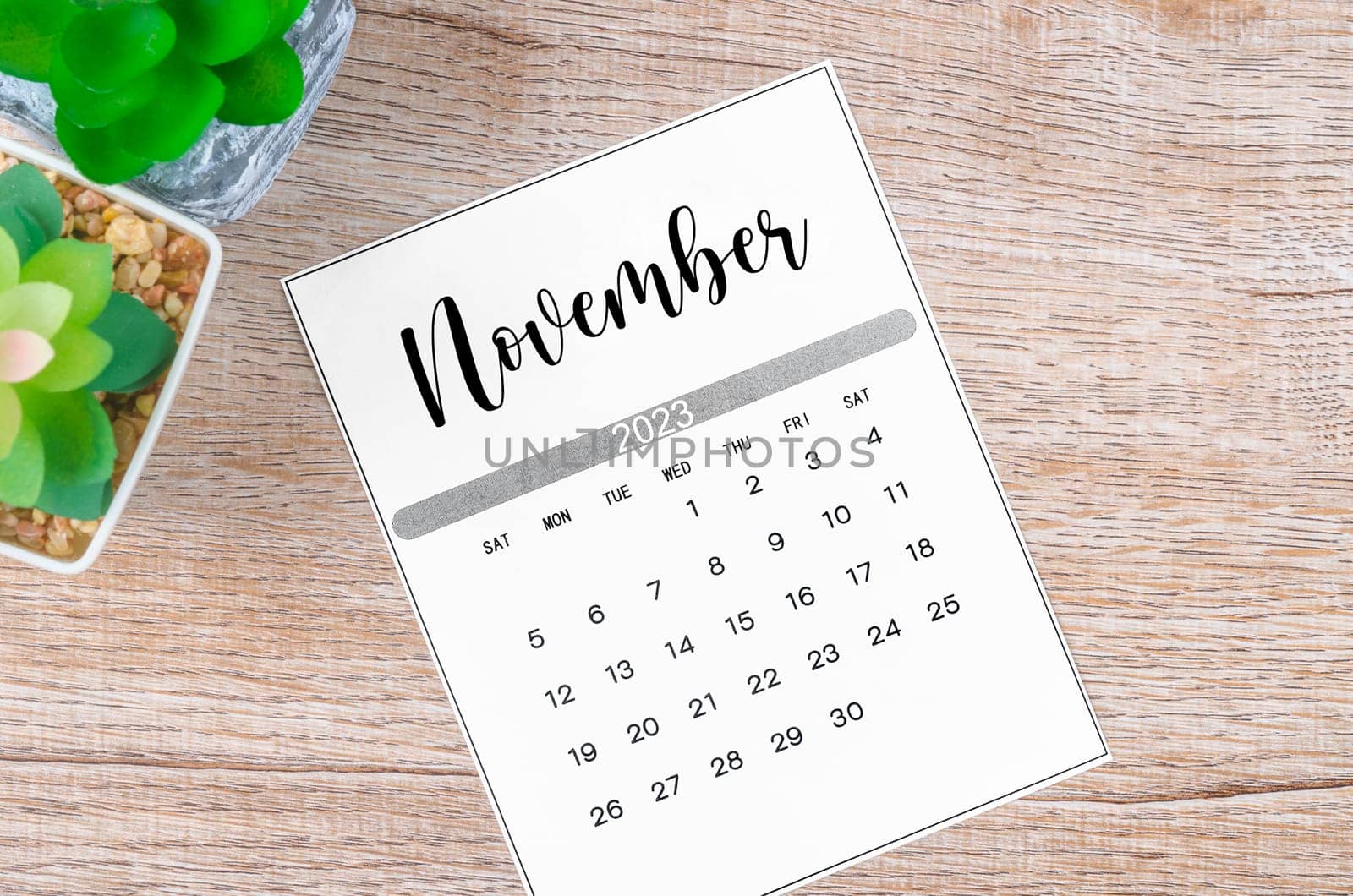 The November 2023 Monthly calendar for 2023 year on wooden background. by Gamjai