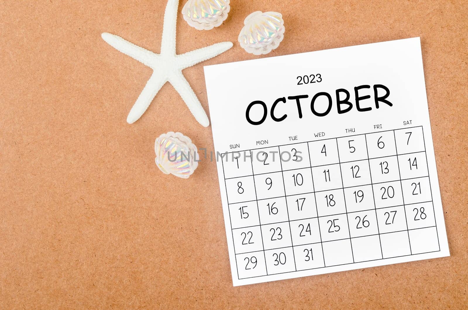 October 2023 Monthly calendar with Starfish on wooden background.