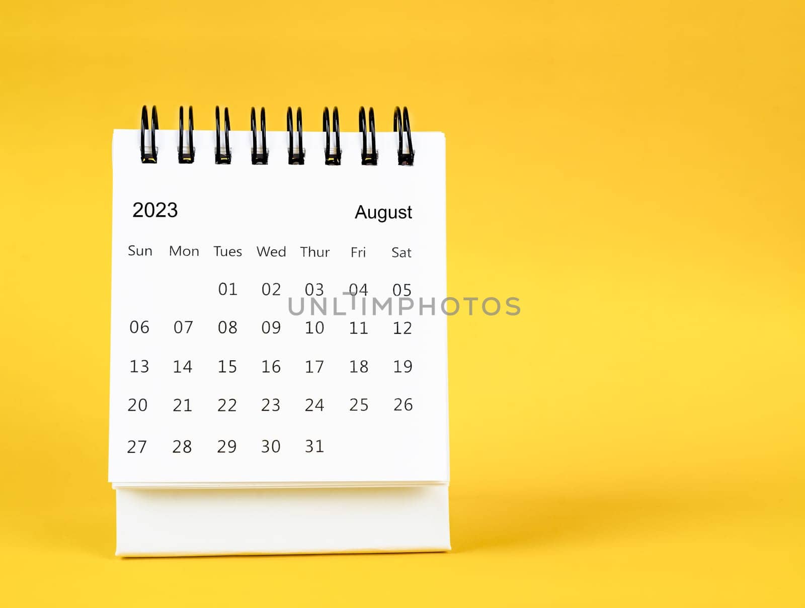 The August 2023 desk calendar on yellow color background. by Gamjai