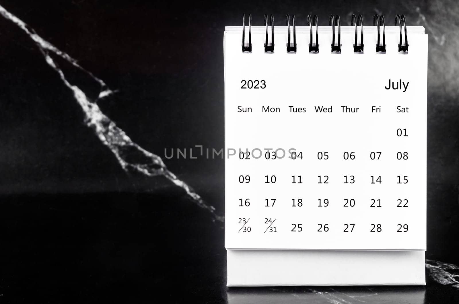 July 2023 Monthly desk calendar for 2023 year on black marble background.