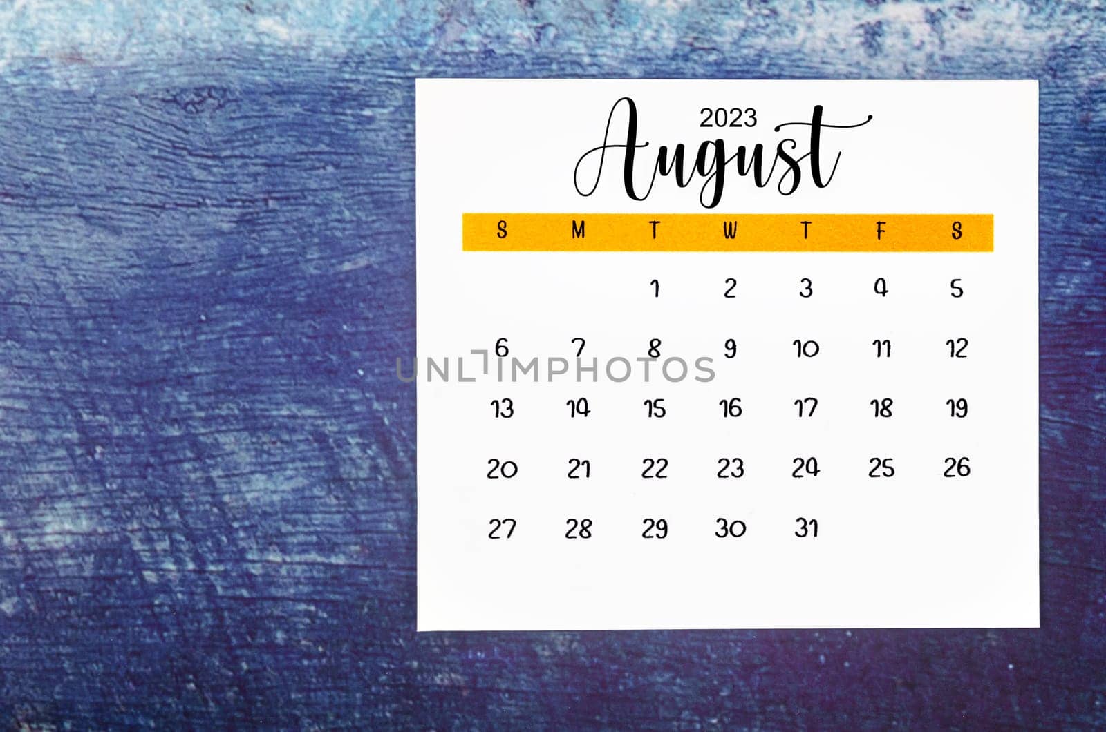 The August 2023 Monthly calendar for 2023 year on old blue wooden background. by Gamjai