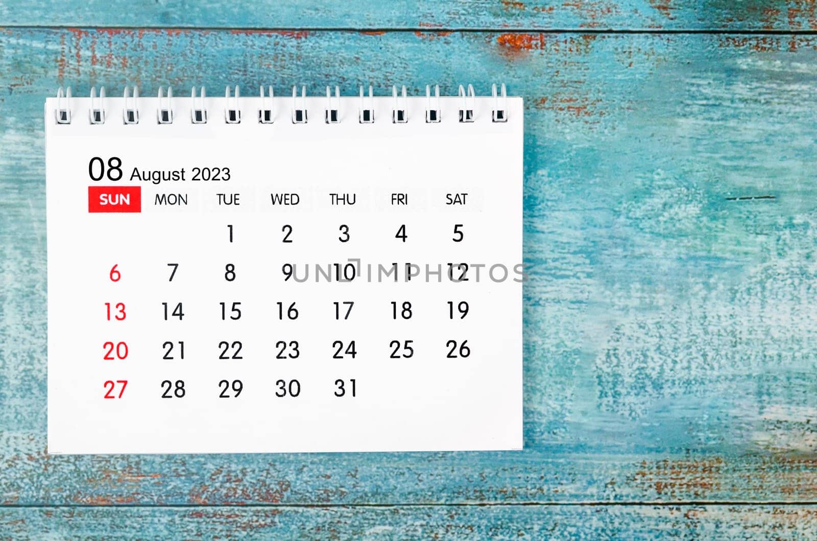The August 2023 Monthly desk calendar for 2023 year on old blue wooden background. by Gamjai