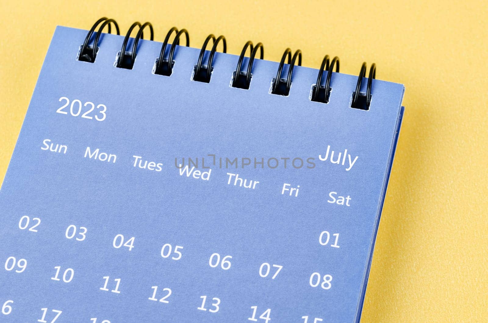 The July 2023 Monthly desk calendar for 2023 year on yellow background. by Gamjai